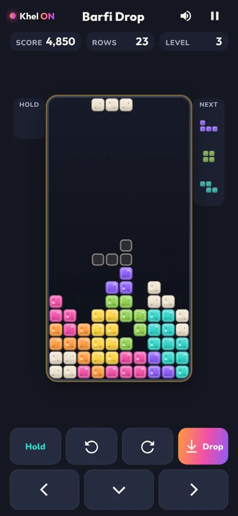 A Barfi Drop game in progress, with the tray part filled with colourful sweets and an outline showing where the falling sweet will land