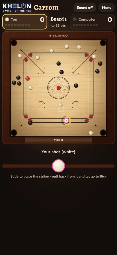 A carrom board mid-game, with a dotted aim line from the striker to a white coin and an arrow showing where the coin will go